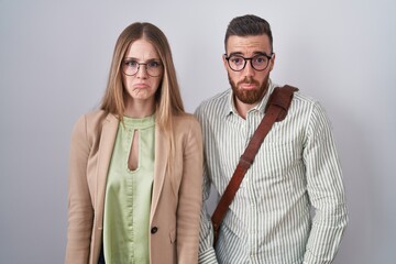 Young couple standing over white background depressed and worry for distress, crying angry and afraid. sad expression.