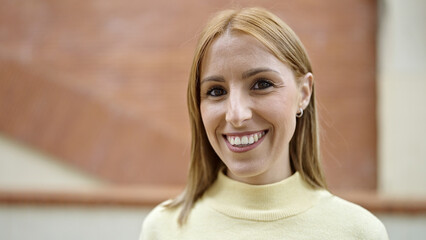 Young blonde woman smiling confident standing at street