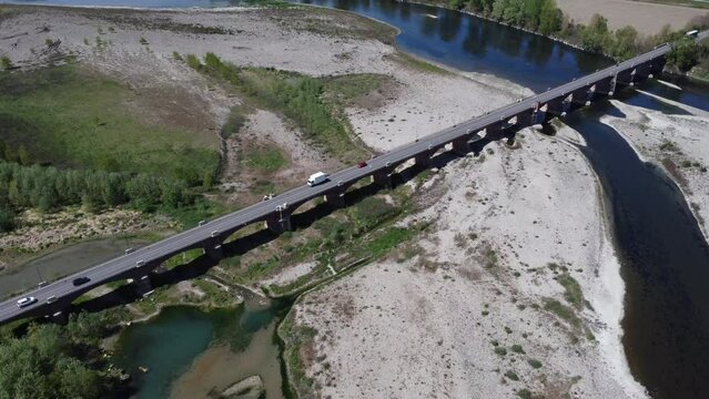 Camion e automobili sulla strada attraversano il ponte sul fiume in secca - fotografia aerea con drone 