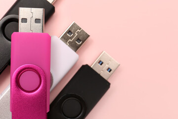 USB flash drives on pink background