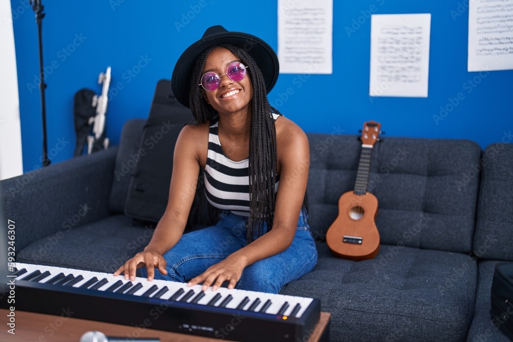 Poster African american woman musician smiling confident playing piano at music studio