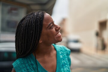 Obraz premium African american woman smiling confident looking to the sky at street