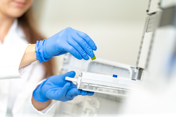 conducting chemical experiments in modern devices in a research laboratory. inserting the container with the solution into the measuring device