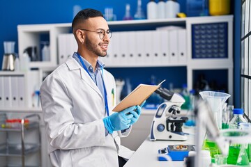 African american man scientist reading book working at laboratory