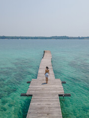 The woman stand alone at wooden bridge in the sea for sightseeing landmark and view