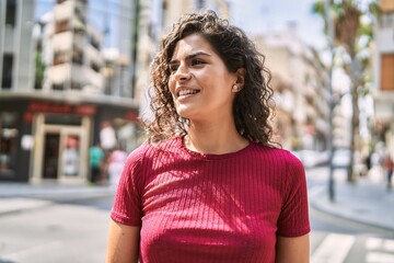Fototapeta na wymiar Young latin woman smiling confident standing at street
