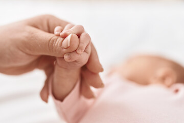 Obraz na płótnie Canvas Adorable hispanic baby holding mother hand at home
