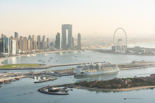DUBAI, VEREINIGTE ARABISCHE EMIRATE - 16.02.2023: Aussicht auf die Skyline von Dubai Marina mit dem Kreuzfahrtschiff AIDAcosma und Riesenrad am Kreuzfahrthafen