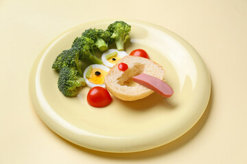 Plate with funny children's breakfast in shape of face on beige background