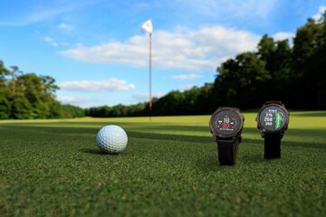 Closeup of smartwatch and golf ball in golf field