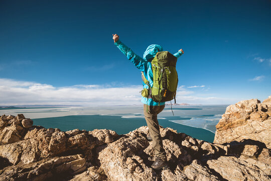 Woman hiker enjoy the ivew on mountain top cliff ege at lakeside