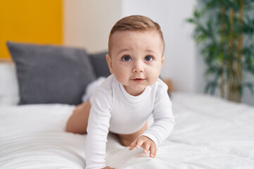 Fototapeta premium Adorable caucasian baby crawling on bed at bedroom
