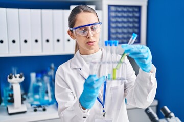 Young woman scientist holding test tubes at laboratory