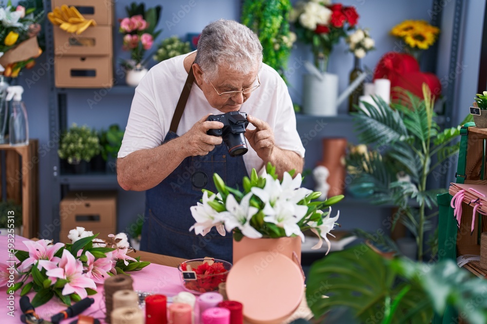 Poster Middle age grey-haired man florist make photo to bouquet of flowers gift at florist