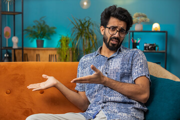 Indian man raising hands asking what why reason of failure, disbelief irritation by troubles,...