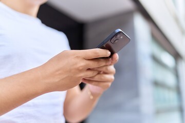 Non binary man using smartphone at street
