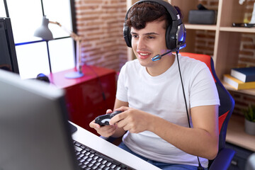 Non binary man streamer playing video game using joystick at gaming room