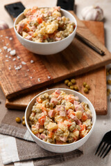 Bowl of tasty Olivier salad on table