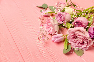 Beautiful flowers on pink wooden background, closeup