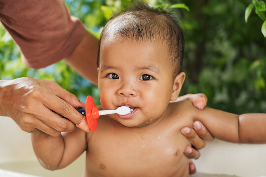 happy Asian Infant to brush teeth with mom. health care and cleaning teeth concept