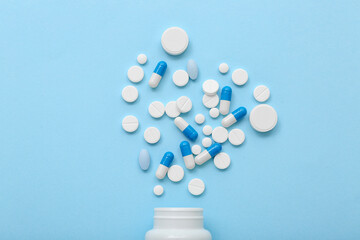 Bottle with pills on blue background