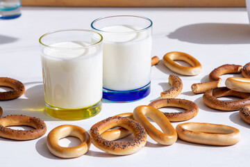 Fresh milk in glasses and bagels with poppy seeds on a table