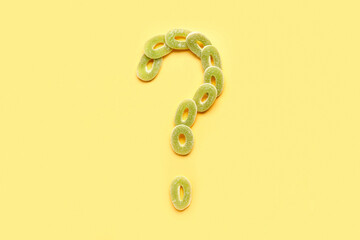 Question mark made of jelly candies on yellow background