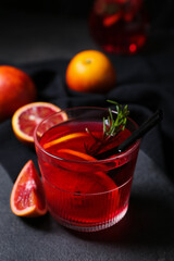 Glass of tasty blood orange lemonade on dark background