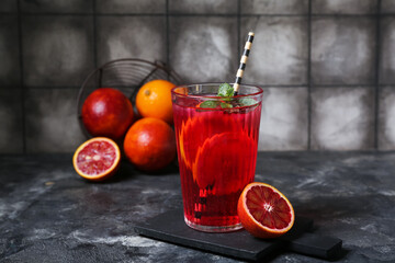 Glass of tasty blood orange lemonade on dark background