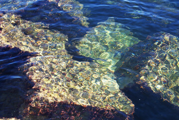 Fototapeta na wymiar Stones at the bottom of the sea, sun glare on the water, underwater world, nature. Background. 