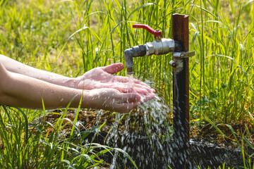 Un homme en train de se laver les mains dans un jardin
