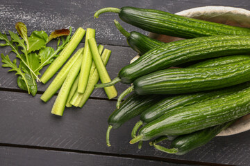 Basket with fresh cucumbers on dark wooden background, closeup
