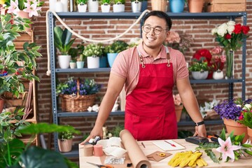 Young chinese man florist smiling confident standing at florist