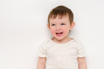A happy baby on a studio white background. Portrait of a smiling child. Kid aged about two years (one year nine months)