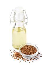 Bottle with flax oil and bowl of seeds on white background