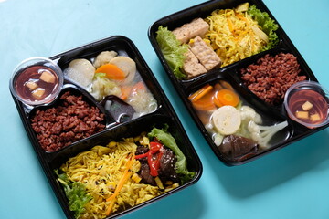 healthy food bento with brown rice, yellow shredded chicken, vegetable soup, tempeh and fruit jelly. For diet weight loss program. healthy lunch menu in a plastic container. catering menu diet. 