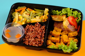 healthy bento. brown rice, Balinese spiced tempeh, beef roulade, stir-fried carrots, baby corn, chickpeas, and fruit pudding. healthy food for weight loss. catering in food container. menu diet sehat.