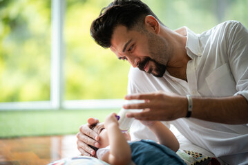 Middle age Caucasian father living with newborn crawling baby, Parent holding rocking child...