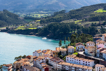 Naklejka na ściany i meble Aerial view of the pretty tourist village of Lastres on the north coast of the Cantabrian Sea in Asturias, Spain.