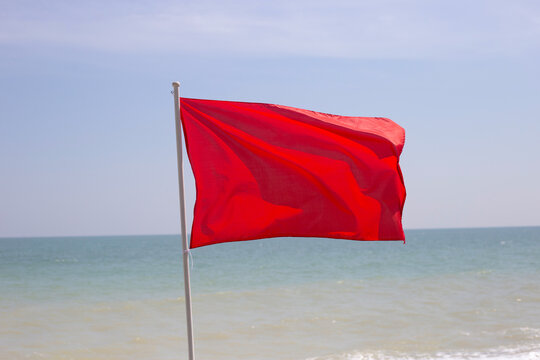 A red flag. Warning sign on the beach