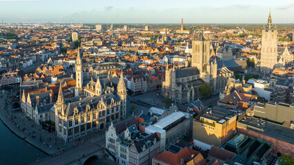 Fototapeta premium Ghent Belgium Aerial Flying over downtown area with church cityscape views at sunset time - October 2022