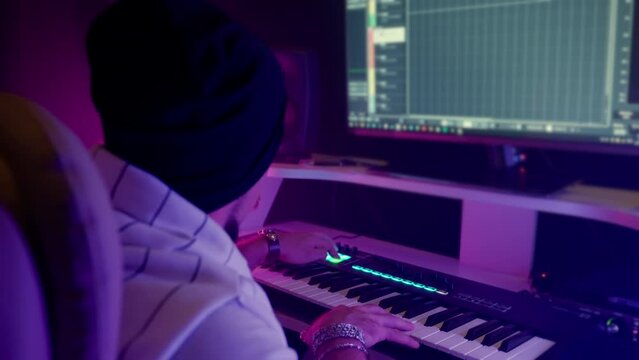 musician or sound designer is working with digital audio workstation DAW with multi-monitor set-up