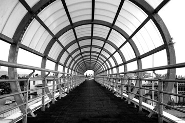 Fototapeta premium Black and white image of a Pedestrian walkway in the city, metal structure of the ceiling in a walkway