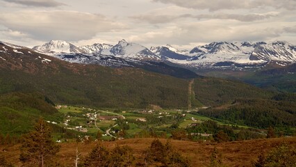 Aerial view of a valley with village houses near snowy mountains in Sjoholt, Norway