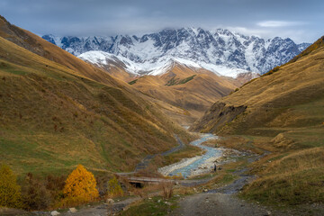 View of the snow valley and flowing stream in the sunny day during autumn season