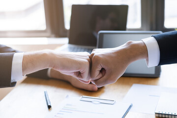 Congrats, business partnership people, two asian and caucasian young man fist bumping, shaking hands together with partnership, customer or colleague after work is done, successful. Worker meeting.