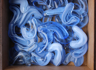 Heap of rough semi-precious blue glass stones in a wooden box top view

