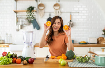 Portrait of beauty healthy asian woman making orange fruit smoothie with blender.young girl preparing cooking detox cleanse with fresh orange juice in kitchen at home.Diet concept.healthy drink