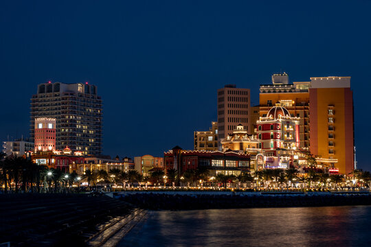 Landscape of the American Village surrounded by lights at night in Chatan, Japan