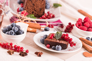 Chocolate sponge cake with fresh fruit on white dish.